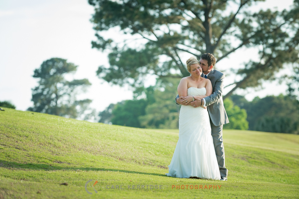 Romantis hug from the groom with his bride on the golf course in Myrtle Beach