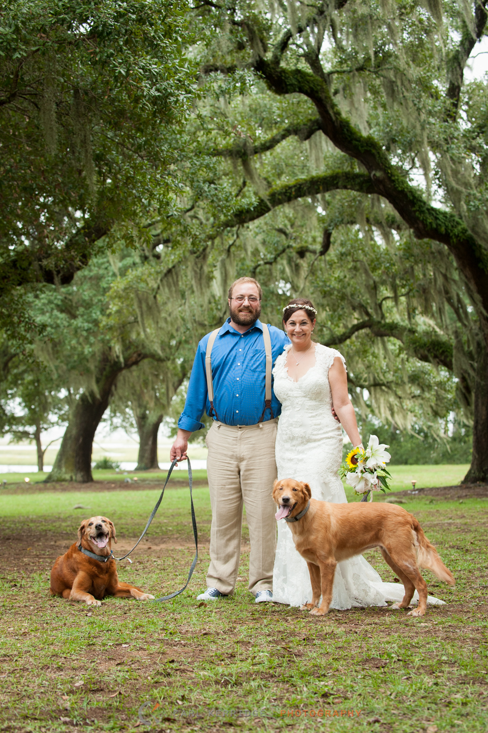 Married couple with their two dogs under the live oak trees at Sunnyside Plantation