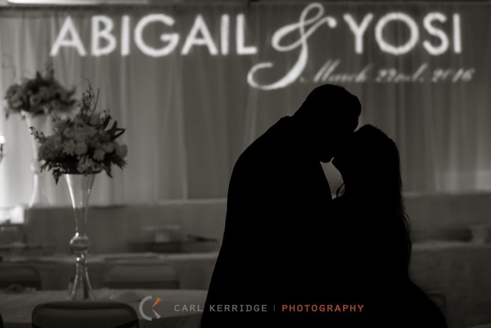 Myrtle Beach wedding, Fine art photography, wedding reception portrait at Hilton Myrtle Beach, silhouette of bride and groom kissing with their names in the background, name in lights on curtain in background