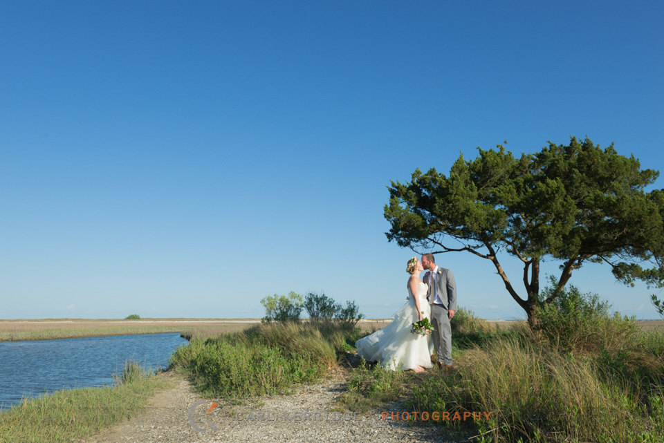 southern wedding, south carolina, wedding, couple, wedding photography, couple kissing, under a tree, blue skies, marsh, beautiful landscape, flower crown