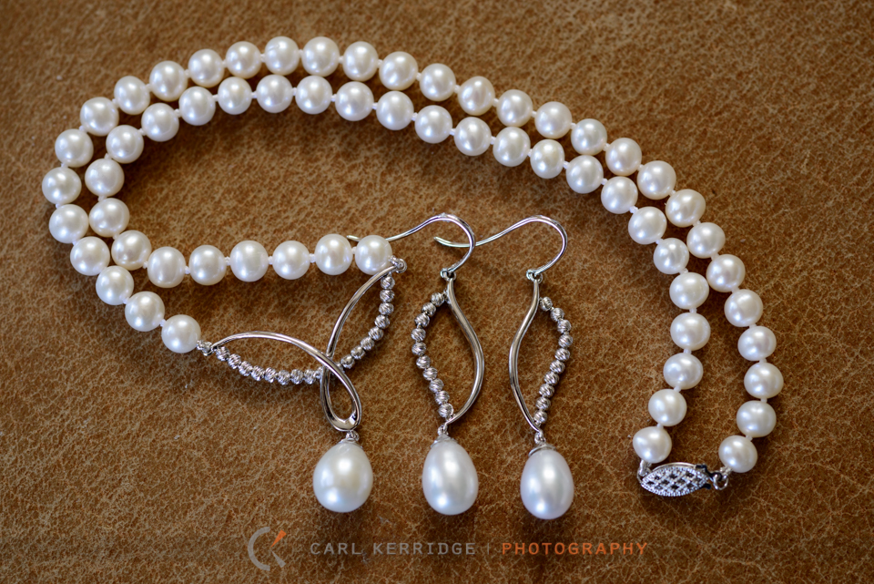 wedding details of bride's necklace and earrings before the couple's Wedding Carriage Ride