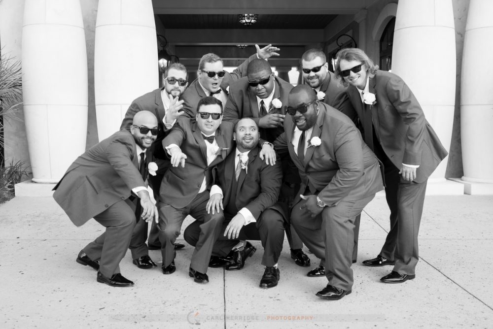 the groom and groomsmen pose for a picture for their wedding photographer