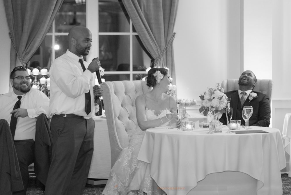the best man makes the groom laugh during the wedding toasts