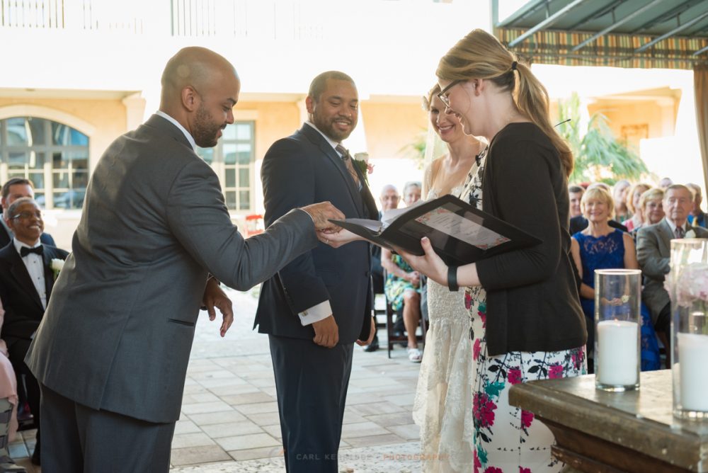 best man gives the wedding officiant the rings during the wedding ceremony