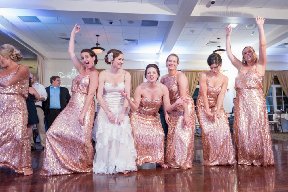the bride and bridesmaids dance and get silly at the wedding reception