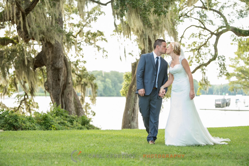 Bride and groom exchange a kiss with the Waccamaw river behind them