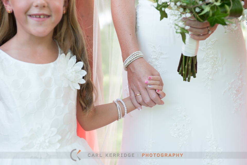 Bride holding hands with flower girl smiling at Wachesaw Plantation