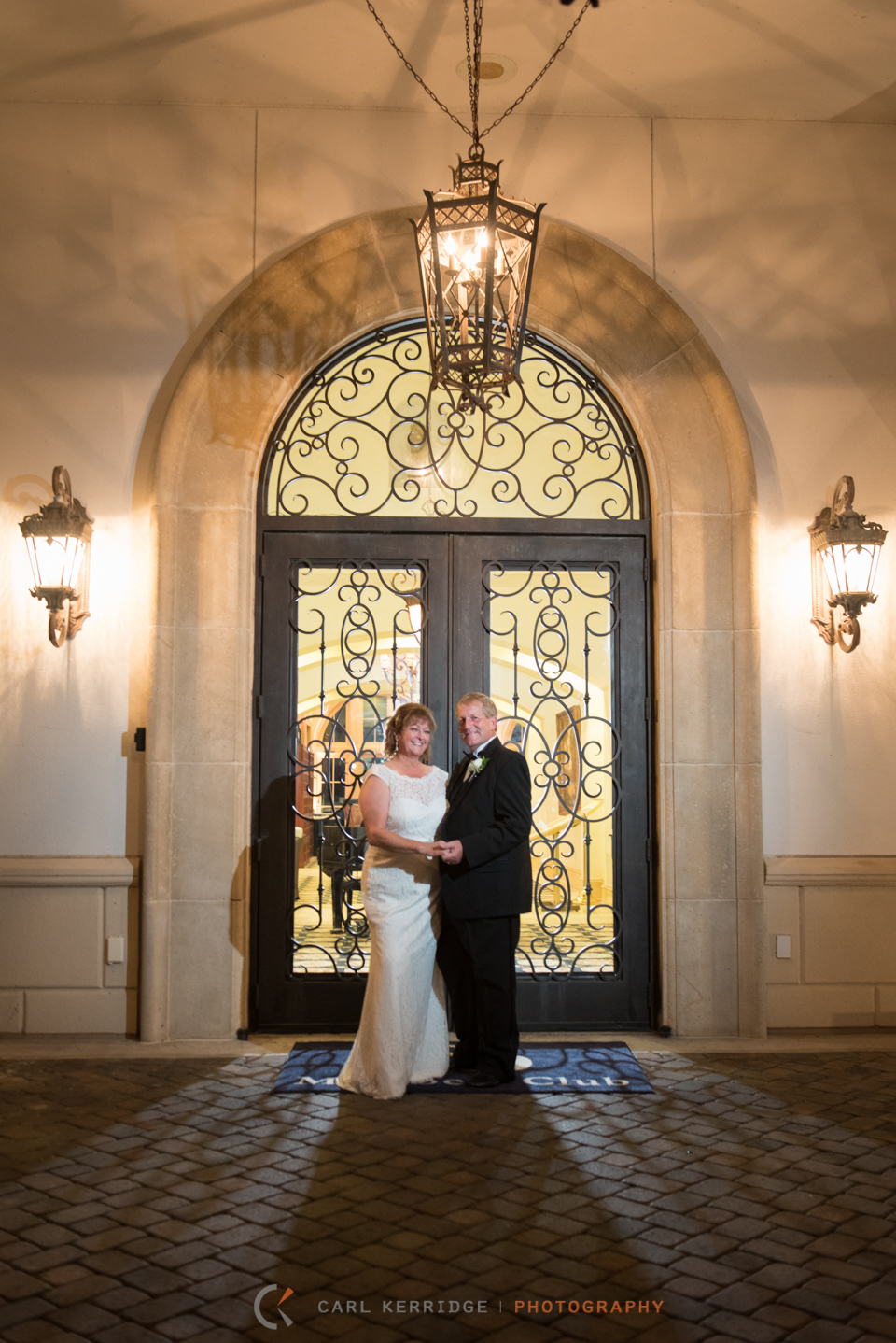 With an atmosphere of love and fun, the couple pose for a portrait in front of the big glass doors at the members club at grande dunes. 