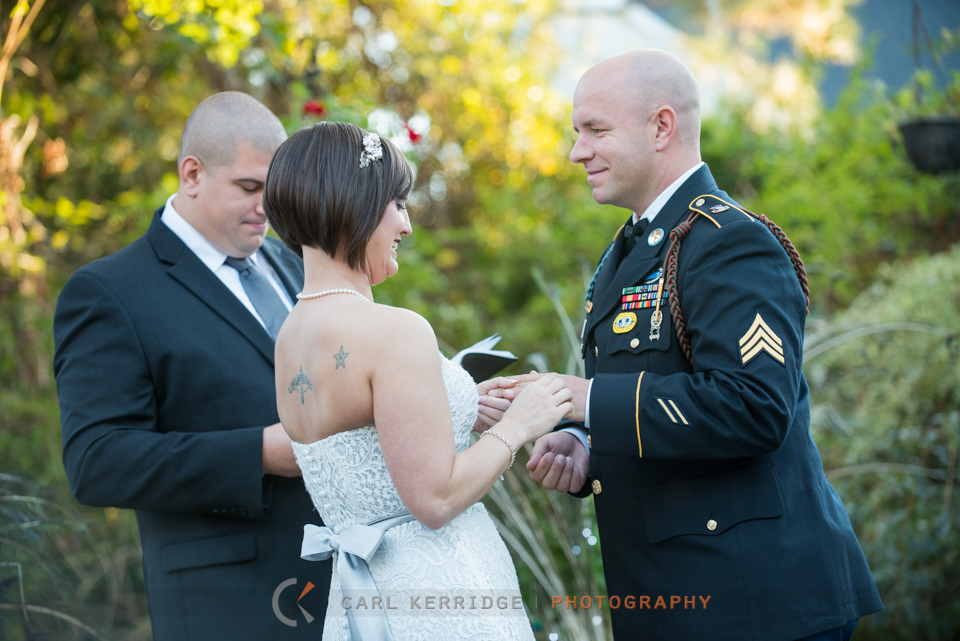 bride places the ring on the grooms finger during the wedding ceremony