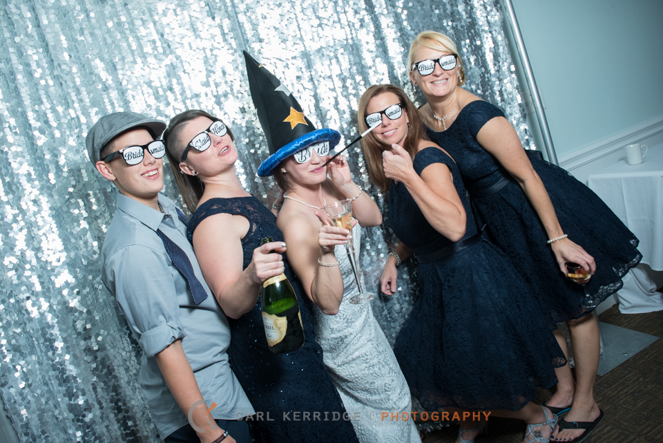 bride and bridal party enjoy the photobooth at the wedding reception