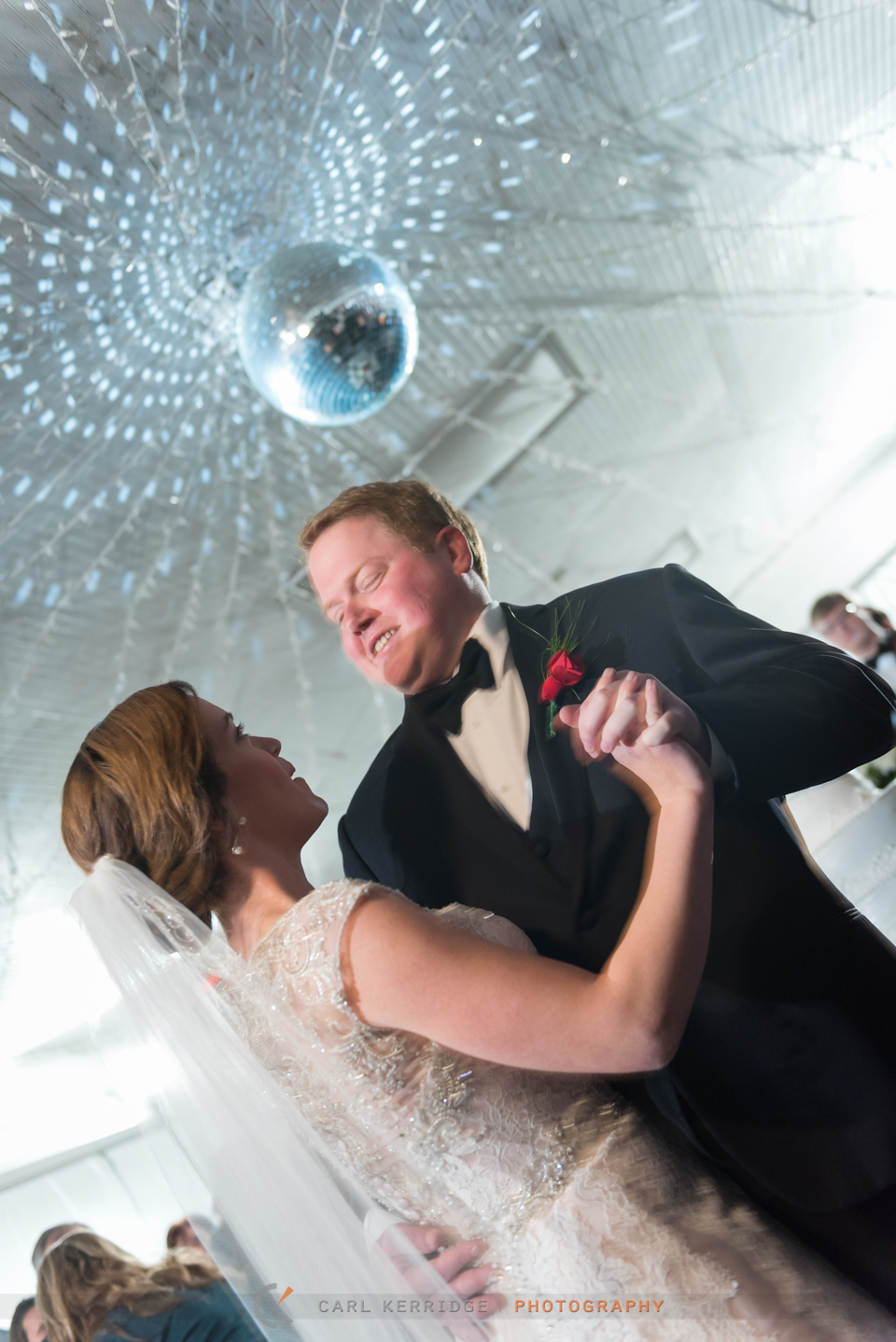 southern bride and her groom dance under a disco light at the wedding reception