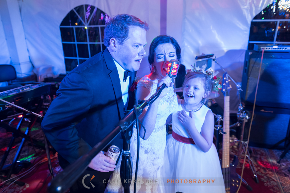 southern bride, groom, and daughter sing a tribute to sweet home alabama at the wedding reception at Rosewood Manor