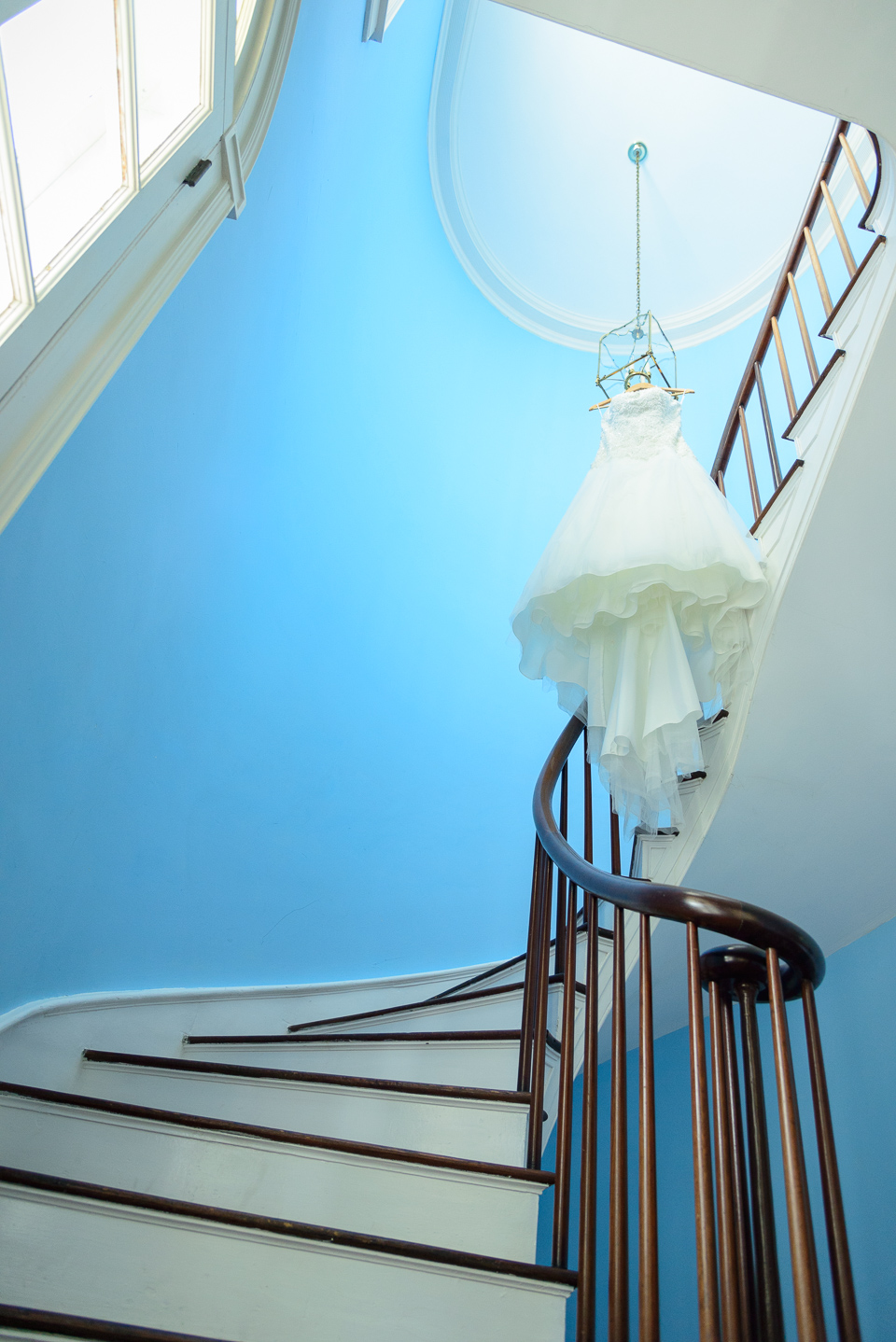 wedding dress hangs from light above staircase before Litchfield Wedding