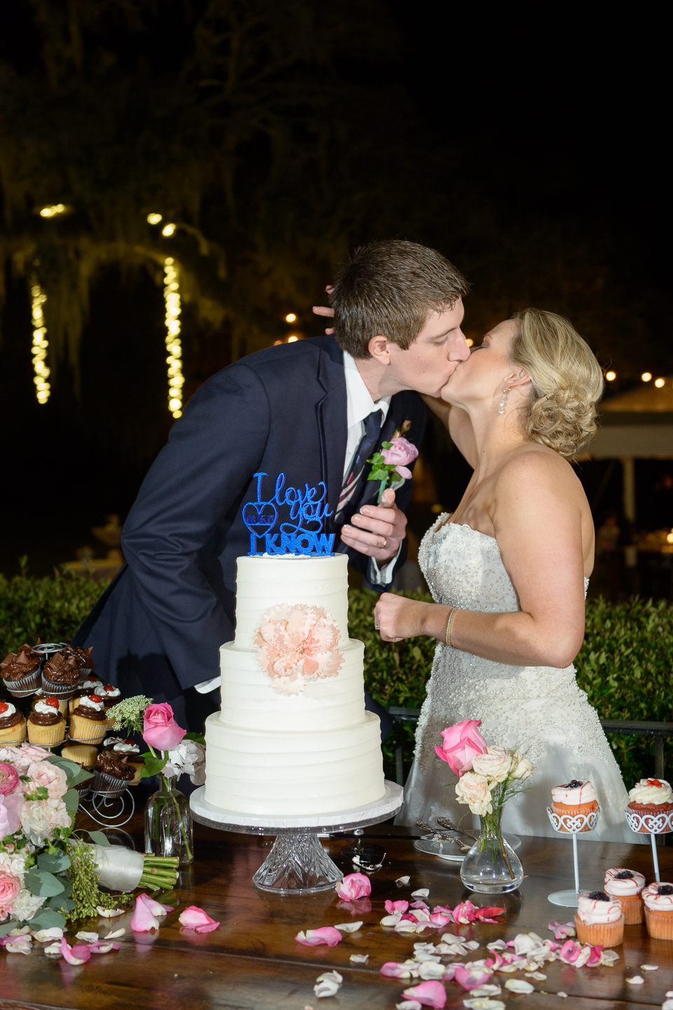 bride and groom kiss after cutting the cake at their Litchfield Wedding reception