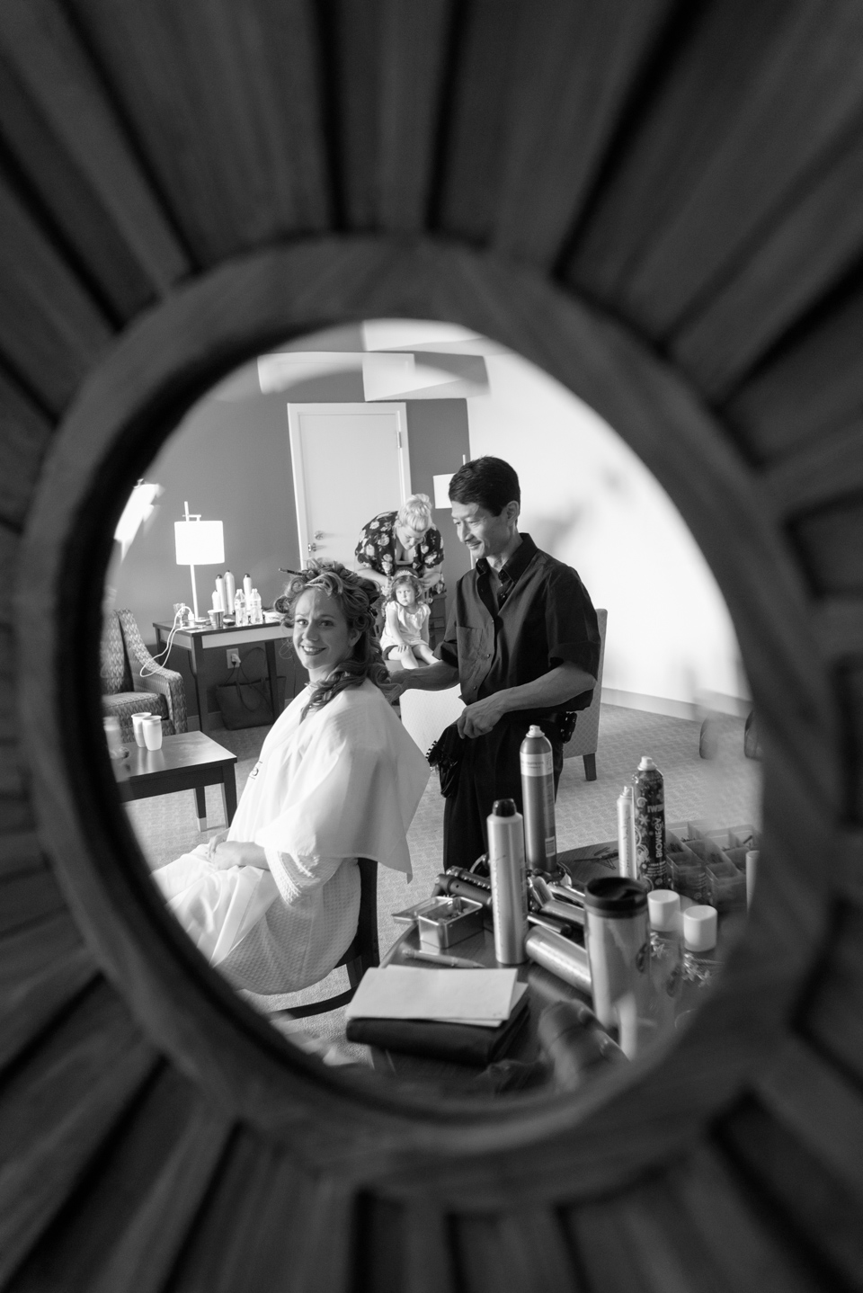 hair stylist and bride are photographed in a candid mirror reflection