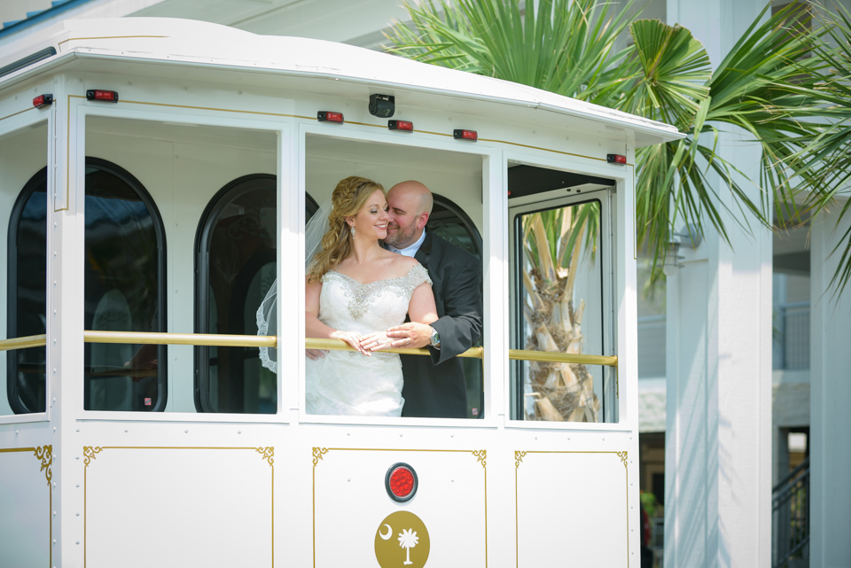 bride and groom cuddle for a couple's portrait on the trolly