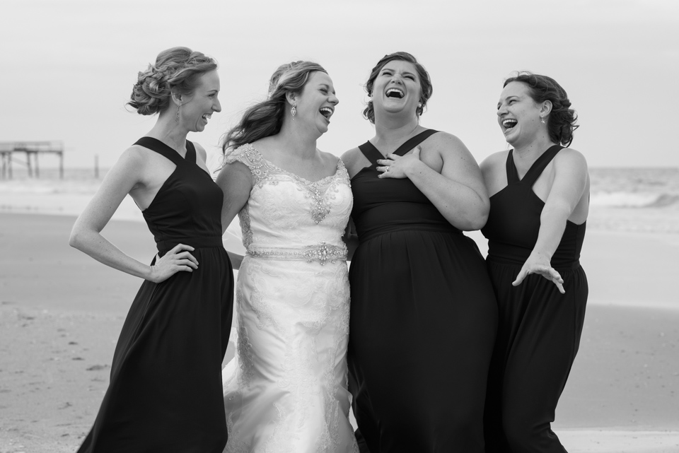 bridal party laugh during portraits on the beach