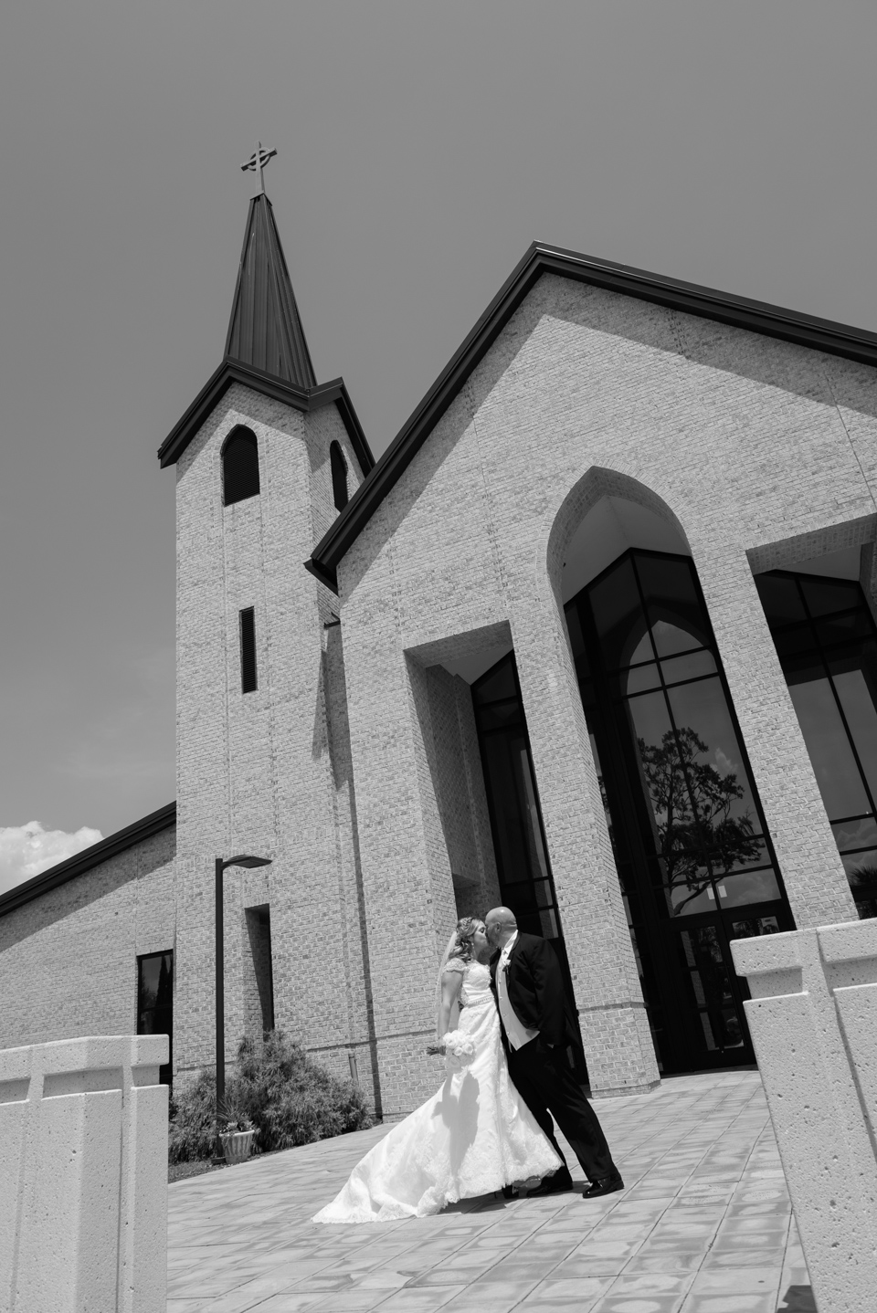 bride and groom kiss in front of St. Michael's Catholic Church