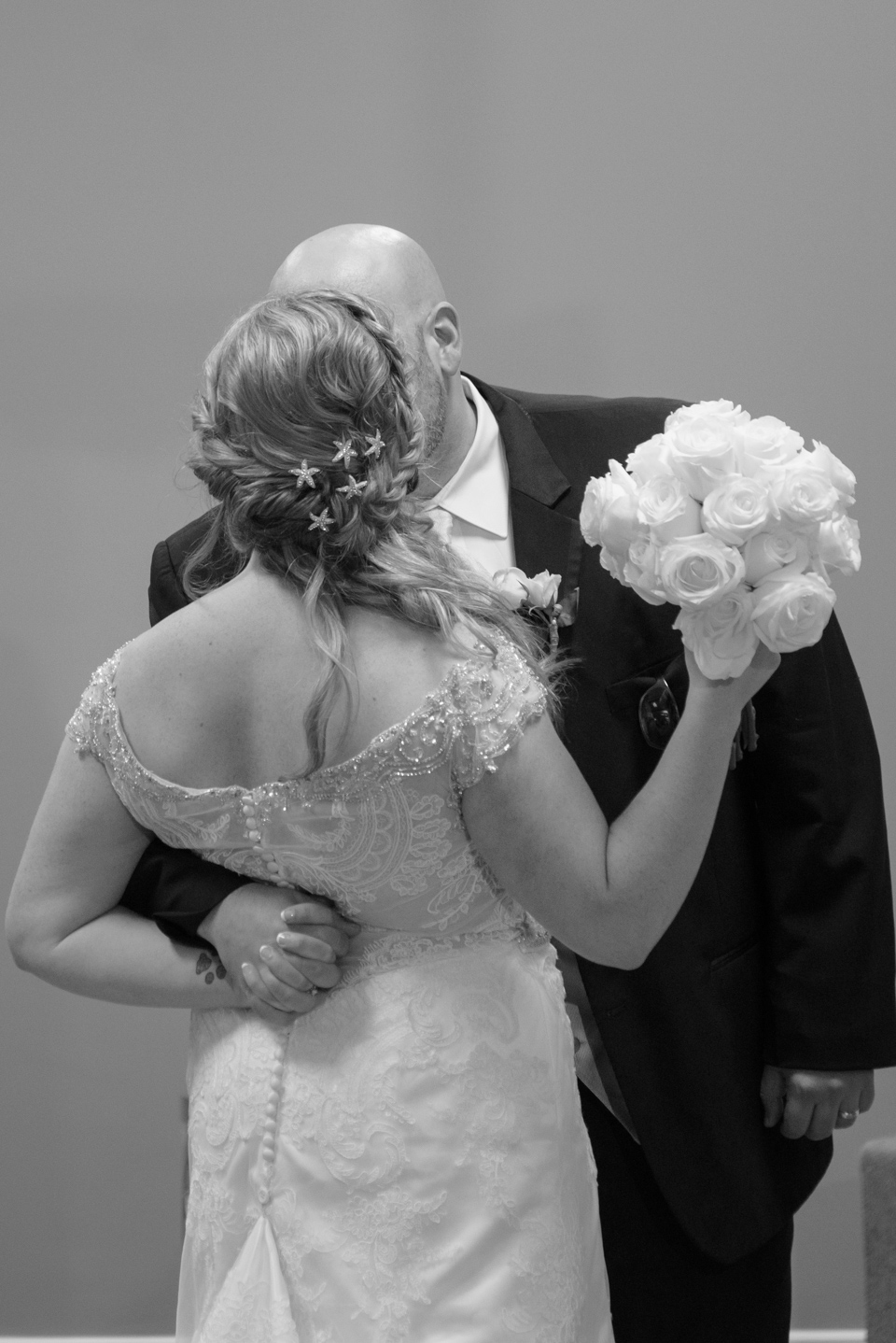 groom sneaks a kiss from his bride before they enter their myrtle beach reception