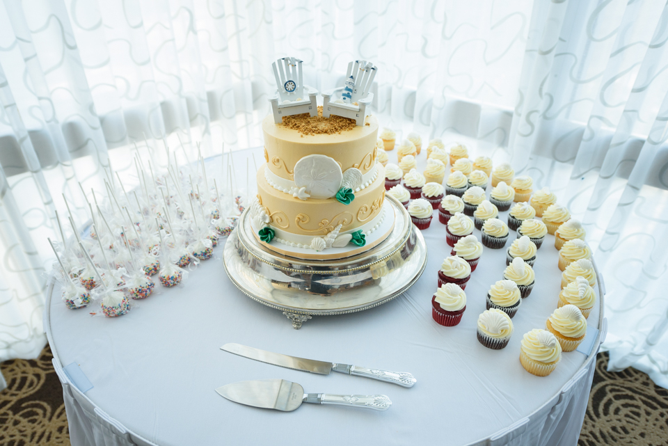 the dessert table included a beach theme wedding cake, cake pops, and cupcakes 