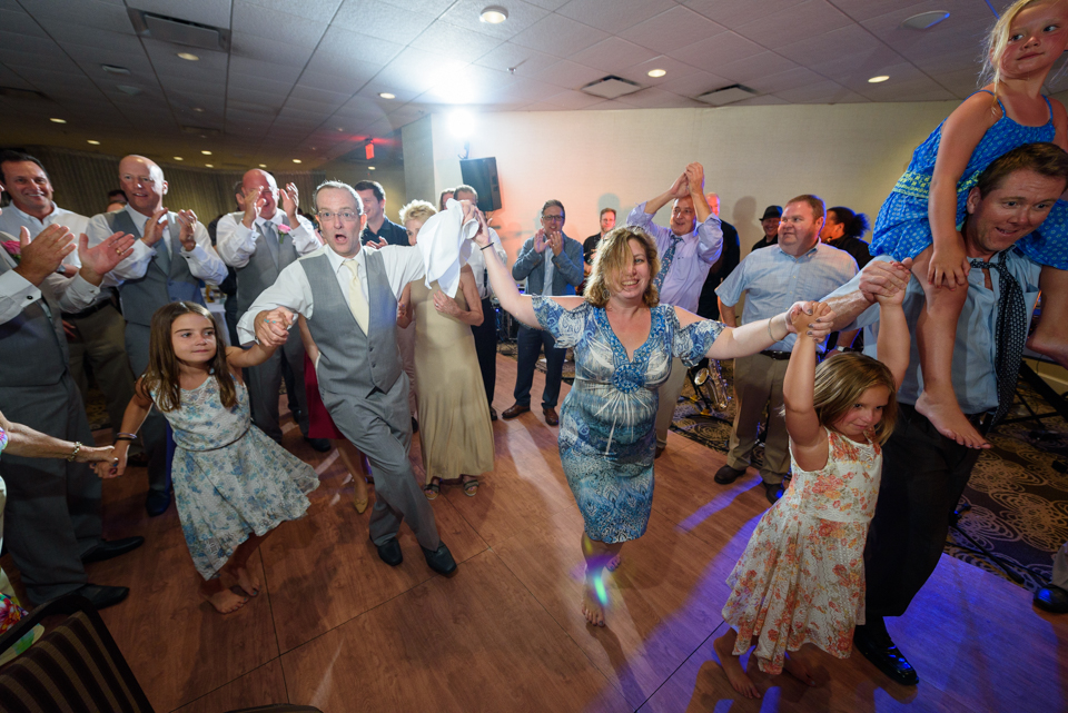 groom dances during a jewish tradition with family and friends